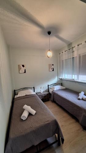 a bedroom with two beds and a window at Nylio Apartment in Preveza