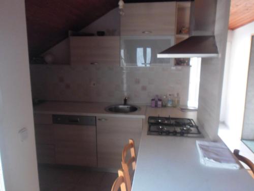 eine kleine Küche mit einer Spüle und einem Herd in der Unterkunft Apartment Doderovic in Kostrena