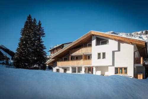 a building with snow in front of it at CHALET ARIA Stay Mountain Relax in Arabba