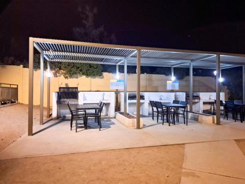 a covered patio with tables and chairs at night at Acogedor departamento en Caldera, Bahía Inglesa, con Aire Acondicionado in Caldera