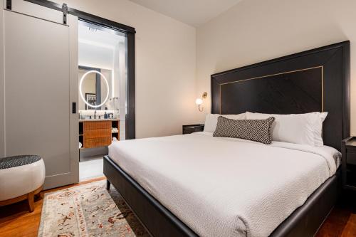 a bedroom with a large bed and a bathroom at The Mayfair in New Orleans