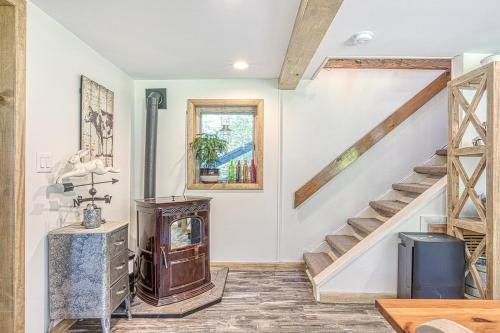 a living room with a staircase and a wooden table at In the clouds your cozy- lake house in Swan Lake