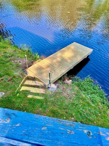a wooden dock on the side of a body of water at In the clouds your cozy- lake house in Swan Lake