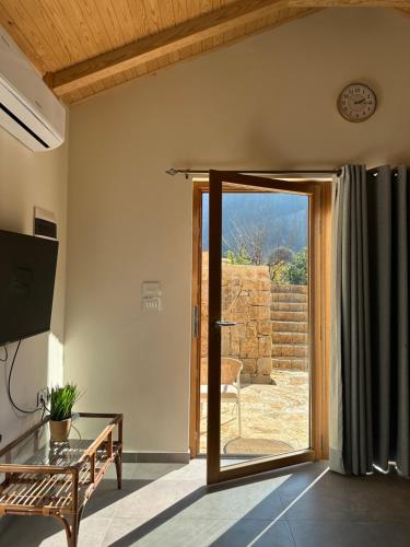a living room with a door open to a patio at Riverside Jahliye, Chouf in Al Jāhilīyah