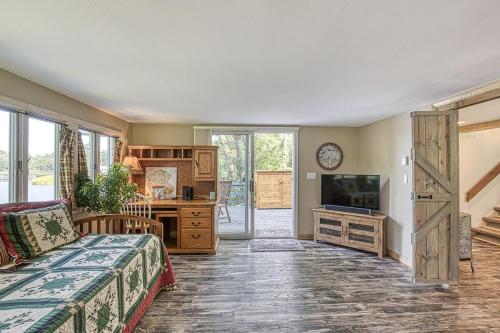 a living room with a bed and a tv at In the clouds your cozy- lake house in Swan Lake