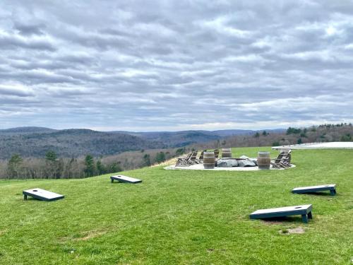 a grassy field with a park with benches on it at In the clouds your cozy- lake house in Swan Lake