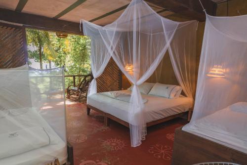 a bedroom with a canopy bed with mosquito net at Isla Fuerte Eco House in Isla Fuerte