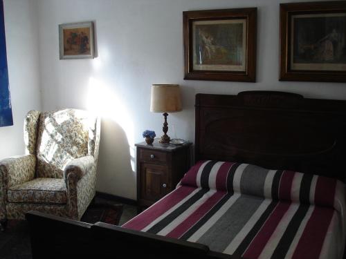 a bedroom with a bed and a chair and a lamp at Casa colonial em Itù - Sorocaba in Mairinque