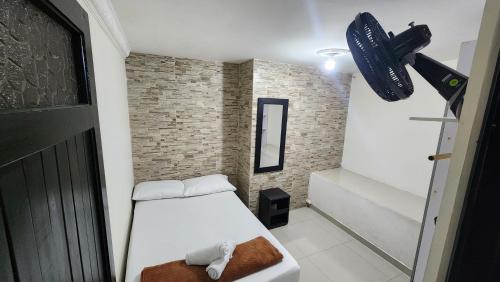 a small room with a bed and a fan at Apartamento Acogedor - San Luis, Ant - Shelter La Perla Hostal in San Luis