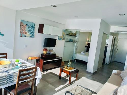a living room with a table and a room with a bed at Acqua Marine in Sesimbra