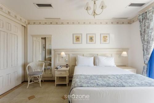 a bedroom with a bed and a desk and a chair at Studios frente ao mar no IL Campanario Resort ILCTOP in Florianópolis