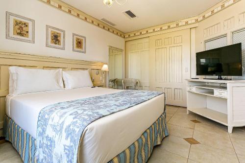 a bedroom with a bed and a flat screen tv at Studios frente ao mar no IL Campanario Resort ILCTOP in Florianópolis