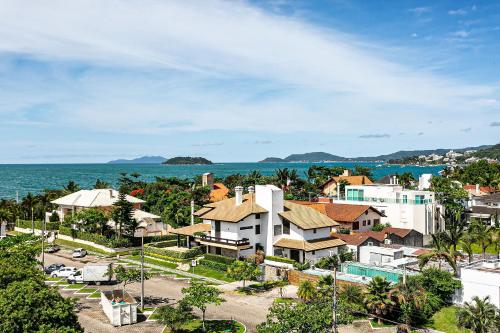 a city with houses and the ocean in the background at Studios frente ao mar no IL Campanario Resort ILCTOP in Florianópolis