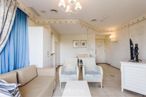 a living room with a couch and chairs and a table at Studios frente ao mar no IL Campanario Resort ILCTOP in Florianópolis