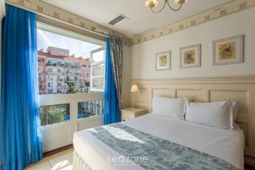 a bedroom with a bed and a large window at Studios frente ao mar no IL Campanario Resort ILCTOP in Florianópolis
