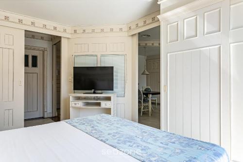 a bedroom with a bed and a flat screen tv at Studios frente ao mar no IL Campanario Resort ILCTOP in Florianópolis