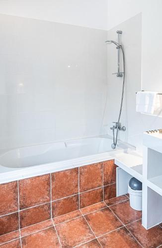 La salle de bains est pourvue d'une baignoire et de carrelage. dans l'établissement La tonnelerie, belle villa pour 9 personnes au coeur d'un vignoble avec piscine, à Sartène