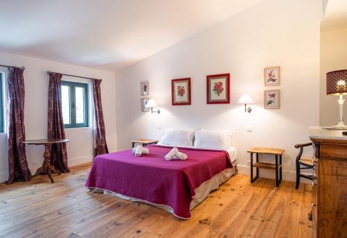 una camera con un letto e una coperta viola di La tonnelerie, belle villa pour 9 personnes au coeur d'un vignoble avec piscine a Sartène