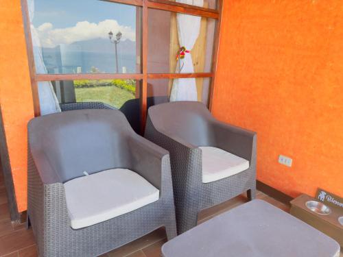 two chairs in a room with a window at Hanna Suites in Panajachel