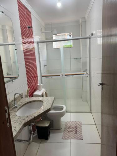 a bathroom with a shower and a toilet and a sink at Hotel Serra do Rio in Ibotirama