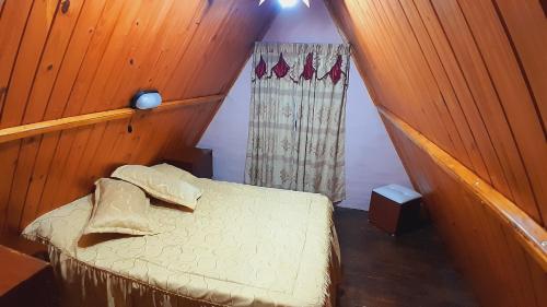 ein kleines Schlafzimmer mit einem Bett und einem Fenster in der Unterkunft Cabanas Junto al Rio in Panaholma