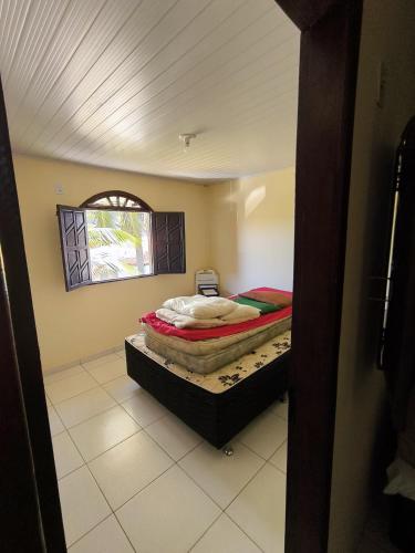 瓦伦萨Casa de veraneio的一间带床的卧室，位于一间有窗户的房间里