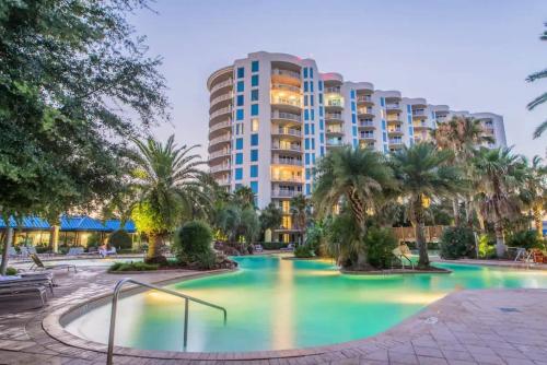 a hotel with a pool in front of a building at Sunrise Surprise 9th floor 2BR 2 BA King Suite Beach shuttle, heated pool! in Destin