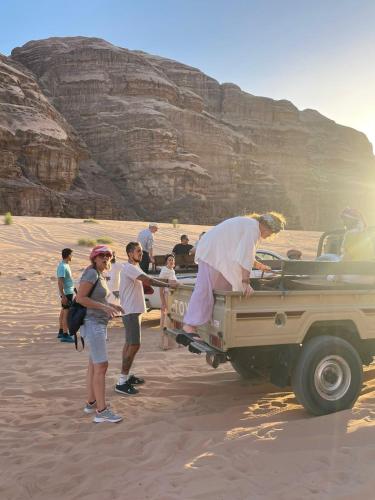 a man standing in the back of a jeep in the desert at مخيم وهج رم in Disah