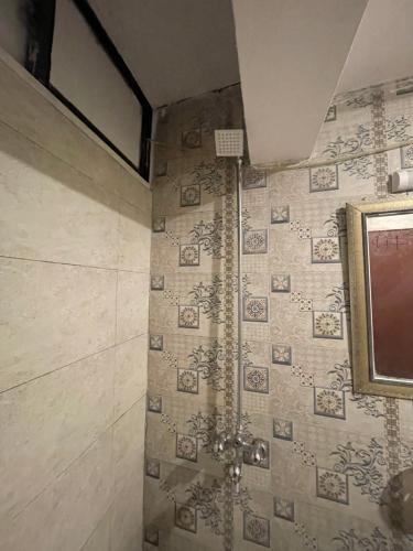 a bathroom with a shower with a tv on the wall at Mussiaree Hotel in Murree