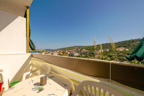 a table and chairs on a balcony with a view at Apartments Naki in Slatine