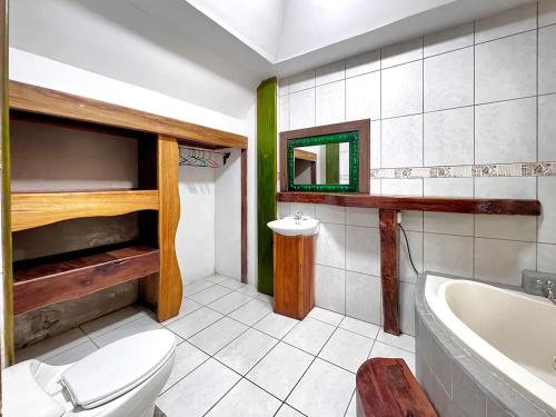 ein Badezimmer mit Toilette, Badewanne und Waschbecken in der Unterkunft Jungle Mansion With Pool - Playa Negra in Hone Creek