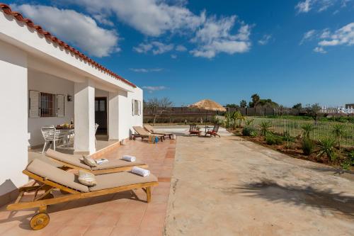 a patio with lounge chairs and a house at New! Villa Air - Cerca de Ibiza - BBQ in Illes Balears