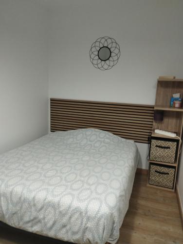 a bedroom with a bed and a clock on the wall at La room in Joue-les-Tours