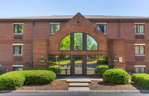 a brick building with an archway in front of it at Suburban Studios-Cary in Cary