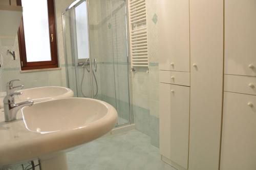 ガリポリにあるResidence Rosa Virginiaのバスルーム(洗面台2台、ガラス張りのシャワー付)