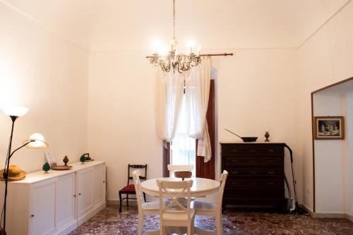 a dining room with a table and a chandelier at La Cortese, cuore barocco in Noto
