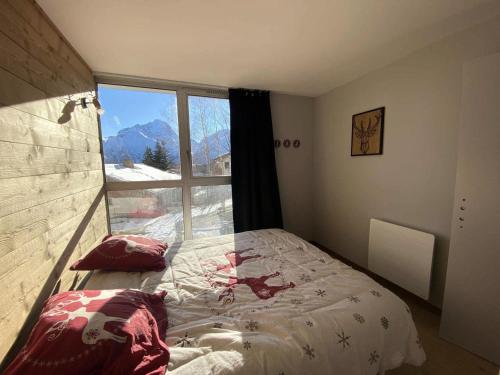 une chambre avec un lit et une grande fenêtre dans l'établissement Résidence Diamant 1 - Spacieux appartement en plein centre de la station des Deux Alpes MAE-1201, à Vénosc