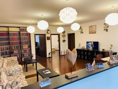 a living room with a couch and a table with books at AUM House in Bucharest