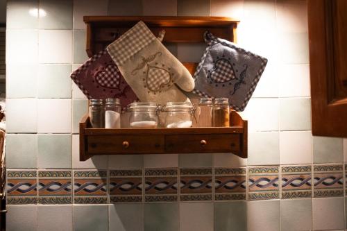 a shelf with glass jars on a wall at La Cortese, cuore barocco in Noto