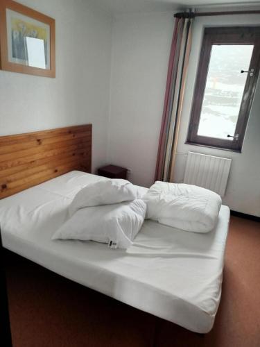 un grand lit blanc dans une chambre avec une fenêtre dans l'établissement Résidence Le Tourmalet - maeva Home - Appartement 3 pièces 8 personnes - Confort MAE-0651, à La Mongie