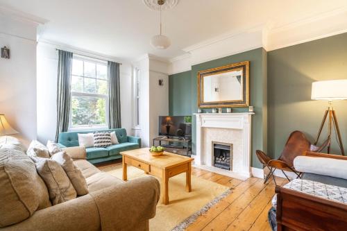 a living room with a couch and a fireplace at Swift Host - 4 Bedrooms - Beautiful Period Property - Parking - Garden in Norwich