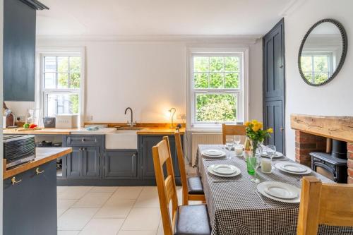 a kitchen with a table with chairs and a sink at Swift Host - 4 Bedrooms - Beautiful Period Property - Parking - Garden in Norwich