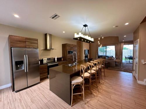 a kitchen with a large island with bar stools at Luxury Home in Orlando with private Hot Tub - 7 Min from Disney Parks - 3 bedrooms and 4 bathrooms! in Orlando