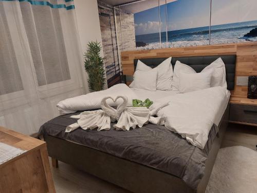 a bedroom with a bed with two swans on it at Happiness Apartman in Kecskemét