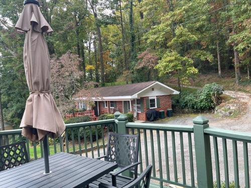 an umbrella sitting on a table on a deck at Mountain Aire Cottages, Inn, & Glamping in Clayton