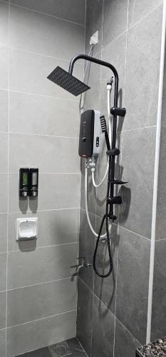 a shower in a bathroom with a phone on the wall at Suria Aman Homestay Semi-D 5 Rooms 5 Bathrooms in Taiping
