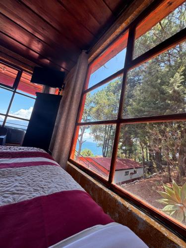 a bedroom with a bed and a large window at Hanna Suites in Panajachel