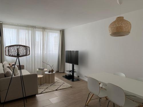 un salon blanc avec un canapé et une table dans l'établissement Apt charme Paris vue & parking, à Paris