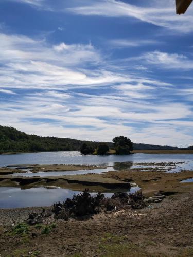 a large body of water with trees in the distance at Cabaña Encanto del humedal Aituy in Aytuy