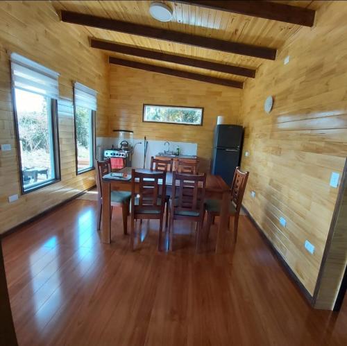 a kitchen and dining room with a table and chairs at Cabaña Encanto del humedal Aituy in Aytuy